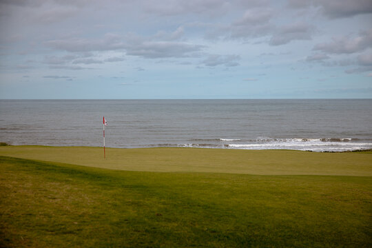 Inverness, Canada - September 18, 2026: Golf flag stands on a green overlooking the Gulf of St. Lawrence at Cabot Links