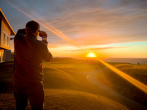 Inverness, Canada - September 18, 2026: Visitor photographs the sunset over the coastal fairways of Cabot Links golf course on Cape Breton Island.