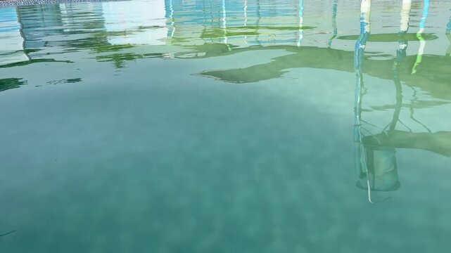 Eye level shot of architectural reflections on turquoise swimming pool water