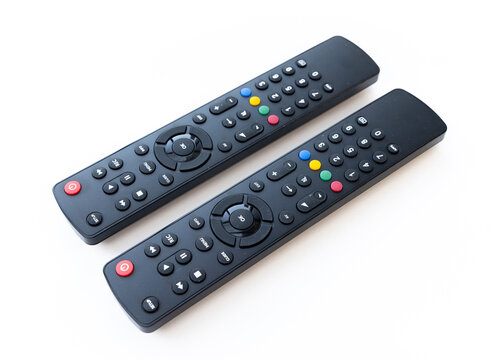 Two modern black remote controls on white background