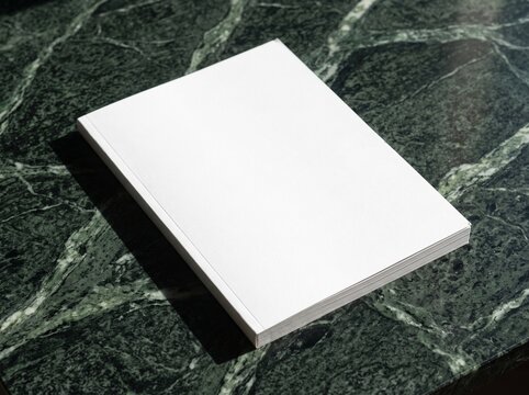Blank white paper stack mock up on green marble texture background
