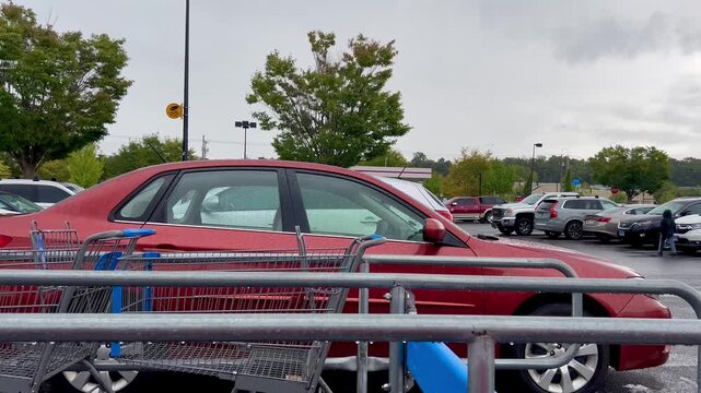 Shopping carts in a store corral during rain in a parking lot