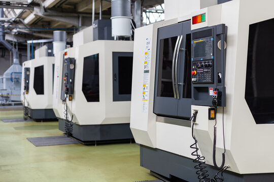 Modern CNC machinery in high-tech manufacturing factory. Industrial automation, precision manufacturing, efficiency, technological advancement, modern engineering processes.