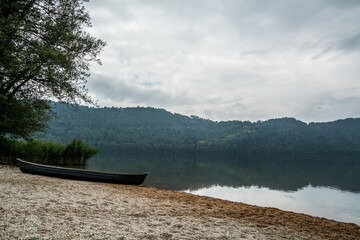Small boat resting on the shore of a calm lake © AT Media Lab