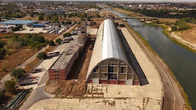 Drone flight toward arched roof of abandoned industrial building