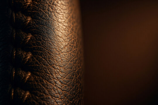Macro stitched steering wheel leather texture showing thumb wear patina for auto insurance