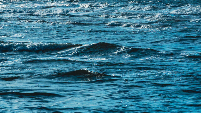 Choppy ocean water surface texture background with white foam waves