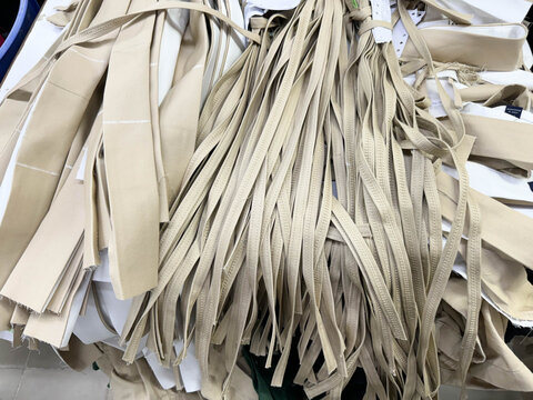 Bundled khaki textile straps in a garment manufacturing workspace