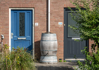 Obraz premium Shared rain barrel in residential street in the netherlands, saving rainwater for garden irrigation
