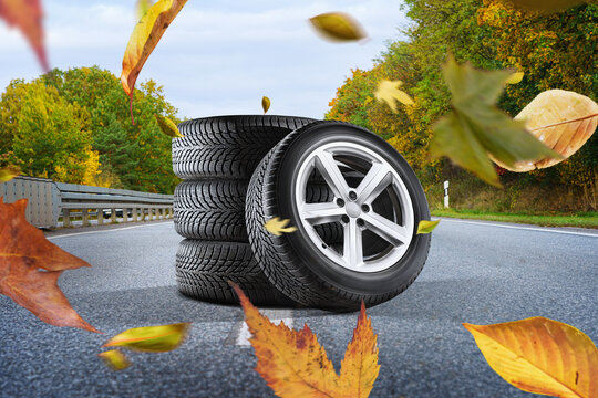 Car tires with on the autumn road - winter tire change concept