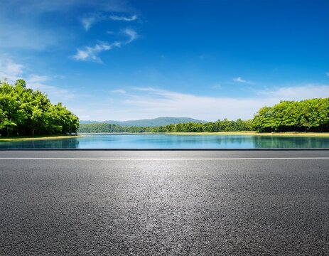 empty asphalt road and green trees with blue sky background over the lake in summer landscape nature view from side of empty street for product display