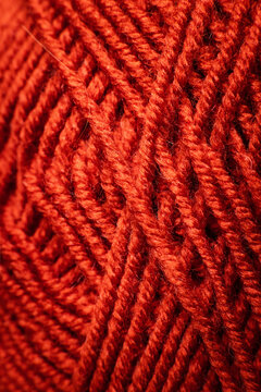 Thin red rope laid flat against a dark background, decorative or utility rope
