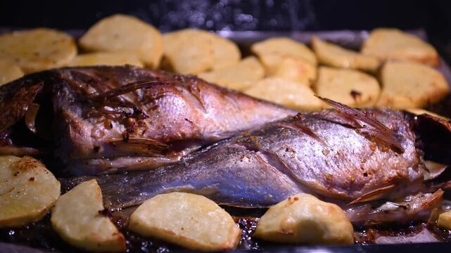 A fresh fish dish baked in the oven with potato slices until tender. A delicious, healthy, and appetizing dinner presentation.