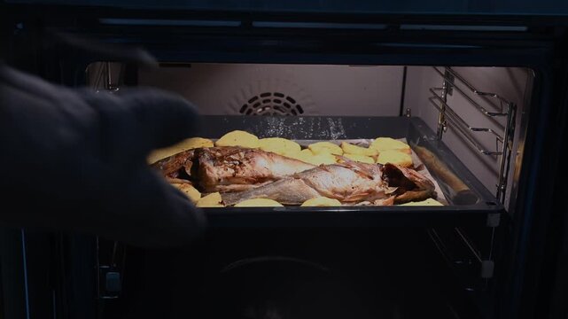The moment the baking sheet of fish with potatoes, roasted to perfection like pomegranates, is taken out of the oven. A delicious and fresh homemade dinner is served.