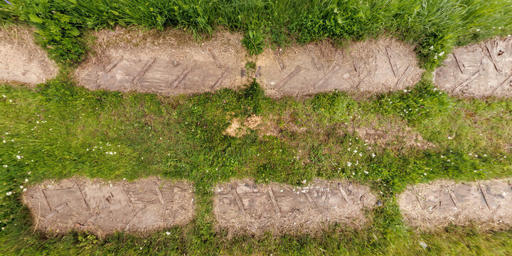 view from above on texture of gravel road among grass field