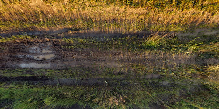 view from above on texture of gravel road among grass field