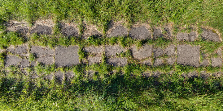 view from above on texture of gravel road among grass field