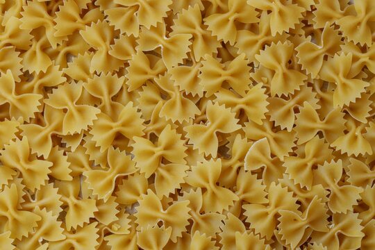 Uncooked Farfalle Pasta, Bow-Tie Macaroni Creating a Lively and Textured Background