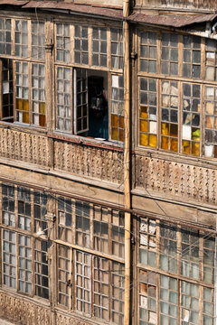 Traditional historic house facade with wooden balconies and windows in old town in Tbilisi, Georgia, aged residential building with wooden windows and carved balustrades, classic Georgian architecture