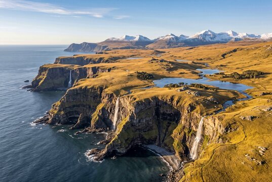 Aerial view of cliffs and coastline with ocean and mountains  