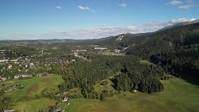 Zakopane - Polska
Widok na kości&oacute;ł, Tatry, Giewont nagrany dronem w słoneczny dzień. Piękne widoki g&oacute;rskie nagrane z powietrza w stolicy Podhala
