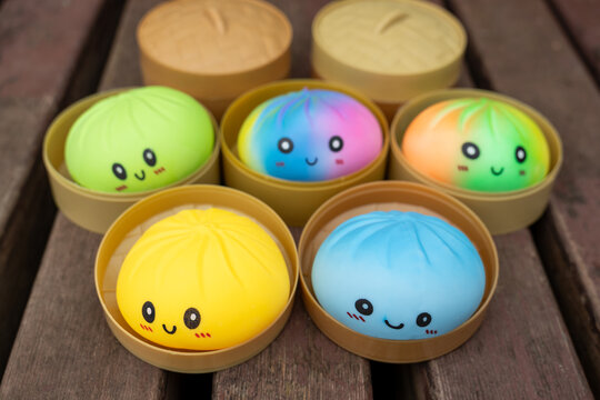 Close up of colorful smiling dumpling shaped squishy toys in bamboo steamers