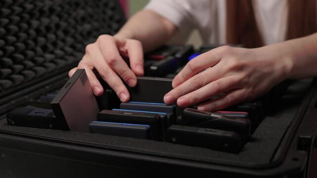 Precise sorting of multiple external storage devices in orderly rows. Systematic placement of various external hard discs emphasizing organization and cataloging principles
