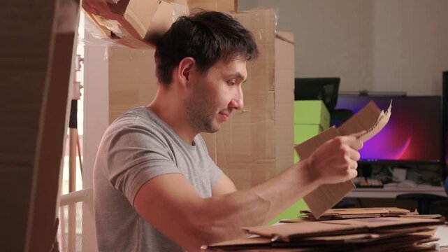 Man packs swiftly. Worker rapidly assembling and sealing packages at busy station. Energetic individual quickly folding and locking tabs on cardboard boxes for shipping
