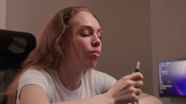 Relaxed lady peacefully using electronic cigarette. Single woman calmly enjoying her vape in quiet surroundings. Young woman with vape device taking tranquil moment to relax