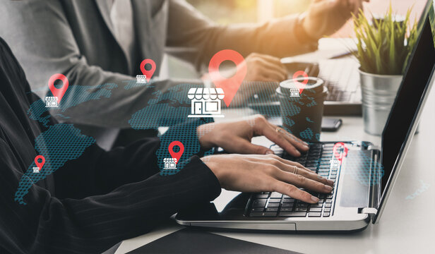 A diverse business team collaborates in a modern office setting, using digital tools on laptops while surrounded by map icons and location markers for global strategy. Gantry