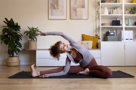 Woman practicing yoga stretching at home for fitness and wellness