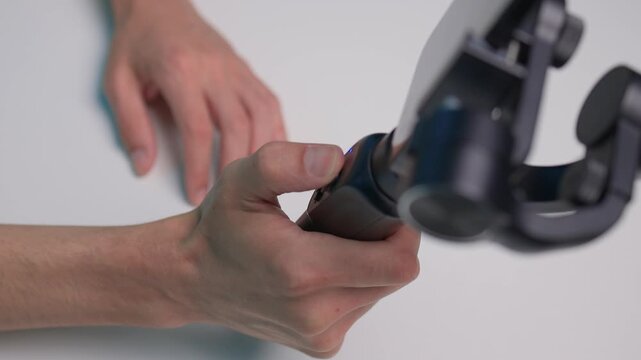 Person adjusts camera stabilizer while smiling in professional studio setup. Person in casual attire is testing camera movement techniques in blue studio environment