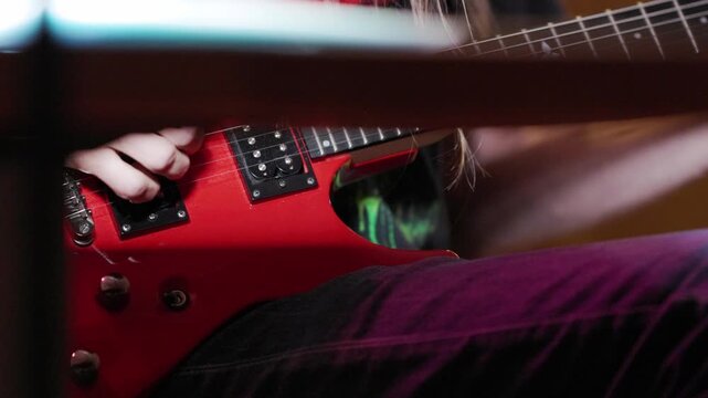 Guitarist playing red electric guitar solo at rehearsal