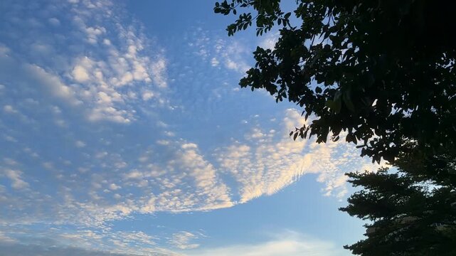 Blue sky with white clouds and the sun. Fast-moving white and gray clouds. Time-lapse photograph of cumulus clouds. Nature time-lapse video in the rainy season. Weather. Sky. Nature.