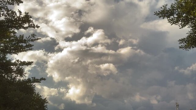 Blue sky with white clouds and the sun. Fast-moving white and gray clouds. Time-lapse photograph of cumulus clouds. Nature time-lapse video in the rainy season. Weather. Sky. Nature.