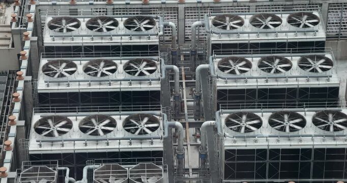 Industrial HVAC cooling system with large ventilation fans on building rooftop. Commercial air conditioning units, engineering infrastructure, energy efficiency, urban building maintenance.
