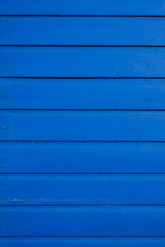 Bright blue painted wooden boards with repeating horizontal stripe pattern