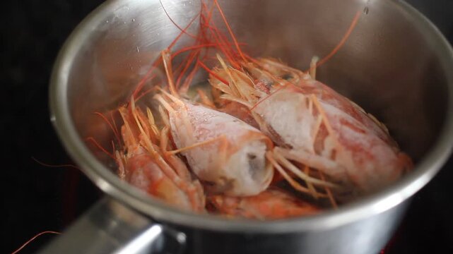 Steaming frozen shrimp heads cooking in a pot on an induction stove