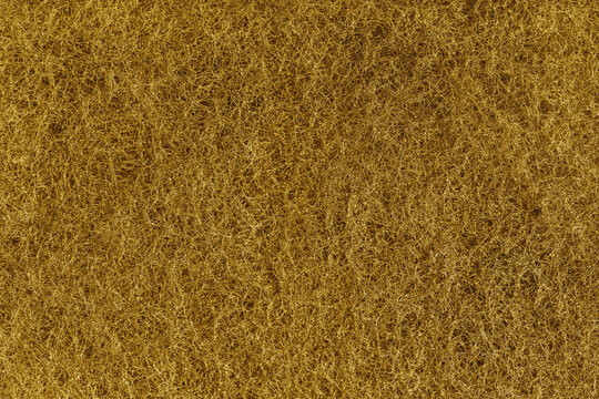 Abstract yellow felt texture with dense fibers, fluffy structure of carpeting or artificial grass close up, macro. Textile surface, material for sports flooring, backgrounds, upholstery and design