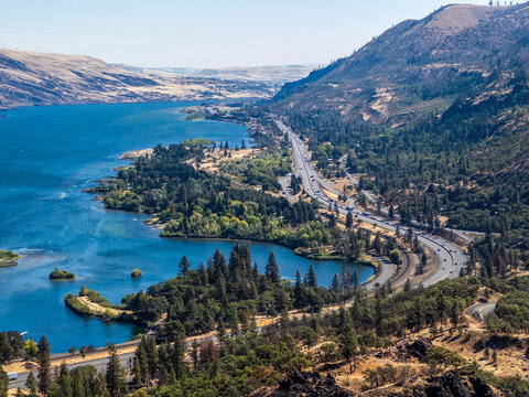 Panoramic view from Rowena Crest Viewpoint over the Columbia River Gorge, with the river, curving highway, forested shoreline, and dry rolling hills in Oregon
