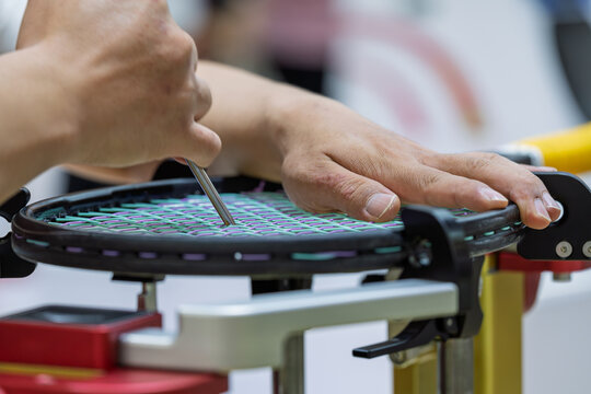 professional technician performing stringing operation for tennis racket