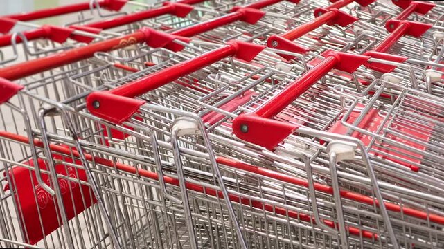 Shopping Carts Stacked at Hypermarket Entrance, Close Up. Rows of empty metal trolleys ready for customers, showing everyday grocery shopping, retail service and consumer activity.