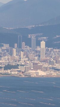 Hiroshima City aerial panoramic view seen from Mount Misen on Miyajima Island, with Seto Inland Sea, Hiroshuma bay and skyline, port and oyster farming rafts, Chugoku, Japan, mountains in background