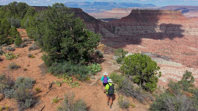 Aerial view of senior couple hiking along Gooseberry Mesa in Utah while taking in views of Zion National Park and its scenic landscape.