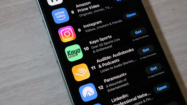Smartphone screen displaying a list of popular mobile application store rankings with black theme.
