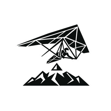 Hang glider silhouette flying over mountains