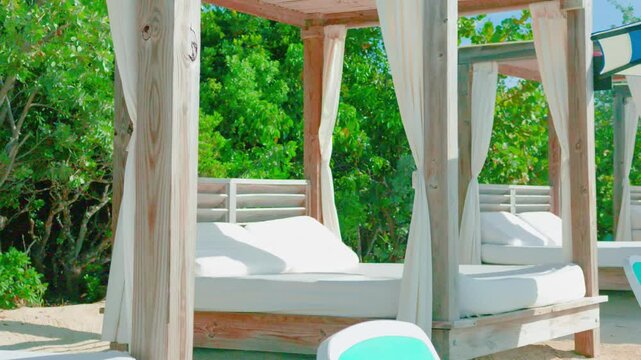 Luxury Wooden Beach Cabanas with Plush White Daybeds and Curtains