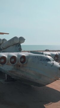 Aerial view of a grounded Soviet-era ekranoplan wing-in-ground effect craft on the Caspian Sea coast near Derbent, Dagestan, Russia, under clear blue sky