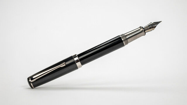 Black fountain pen with silver clip and nib on white background, writing instrument black pen