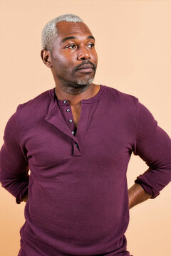 A medium portrait of a silver haired man in a plum henley shirt